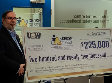 A large 225.000$ cheque being displayed with a CROSH logo on it 
